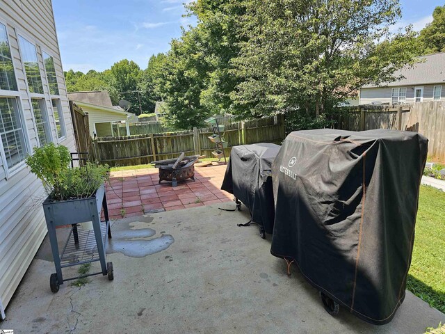 view of patio / terrace with area for grilling, a fenced backyard, and an outdoor fire pit