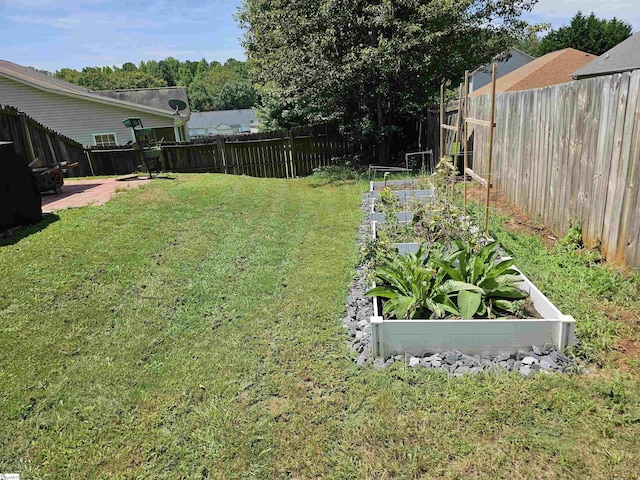 view of yard with a vegetable garden and a fenced backyard