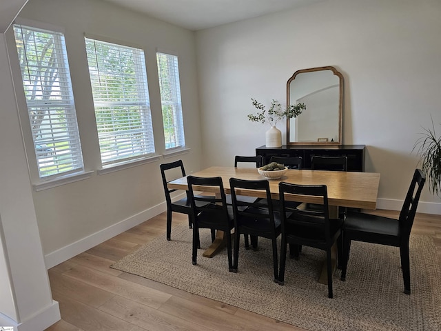 dining space with baseboards, a healthy amount of sunlight, and light wood-style flooring