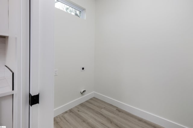 washroom featuring laundry area, electric dryer hookup, light wood-style floors, and baseboards