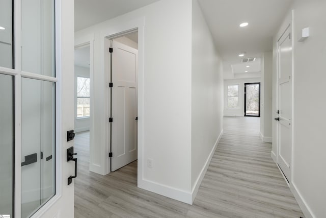 hall with recessed lighting, baseboards, plenty of natural light, and light wood-style floors