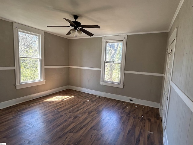 empty room featuring ornamental molding, wood finished floors, and a healthy amount of sunlight