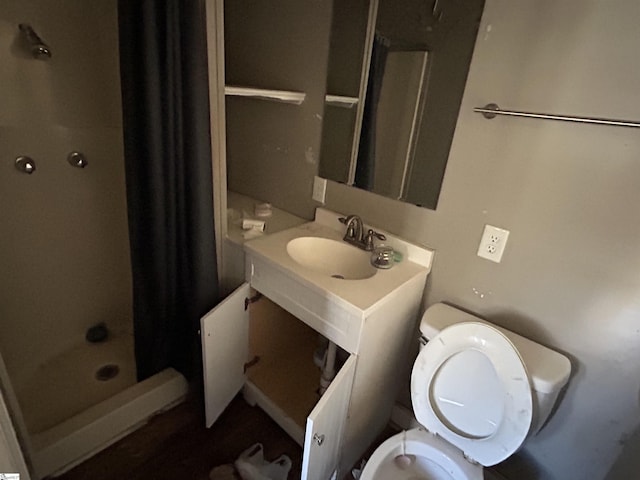 full bathroom featuring a shower stall, toilet, and vanity