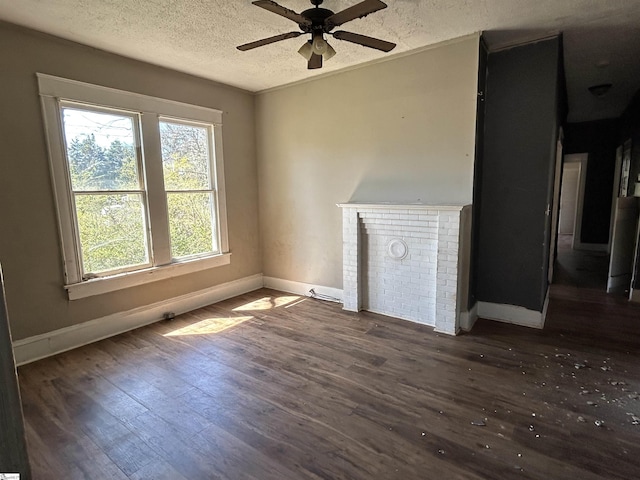 unfurnished living room with ceiling fan, baseboards, a textured ceiling, and wood finished floors