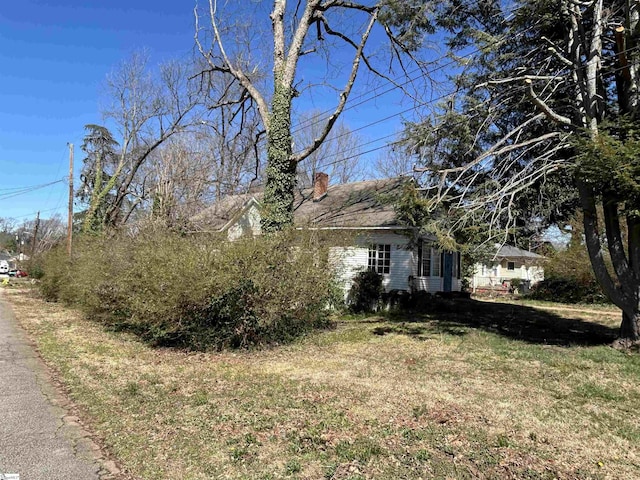 exterior space featuring a lawn and a chimney