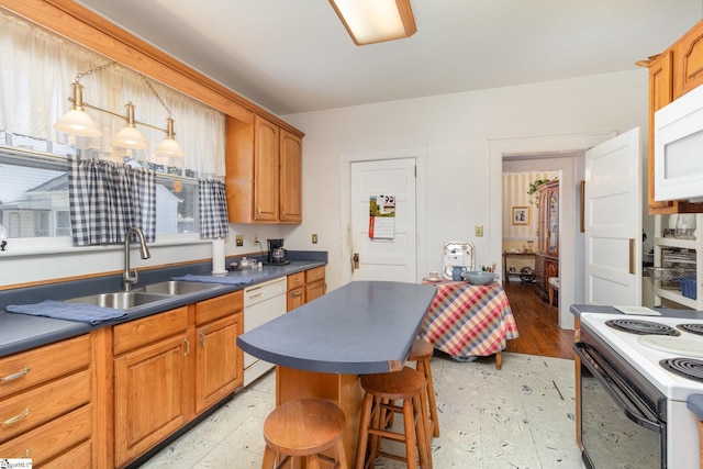 kitchen featuring dark countertops, light floors, white appliances, and a sink