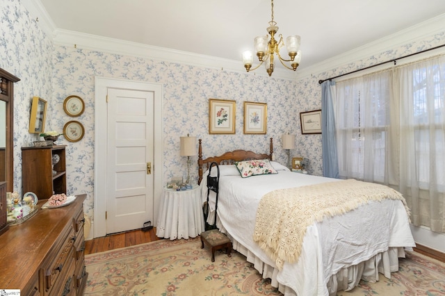 bedroom featuring a chandelier, wallpapered walls, crown molding, and wood finished floors