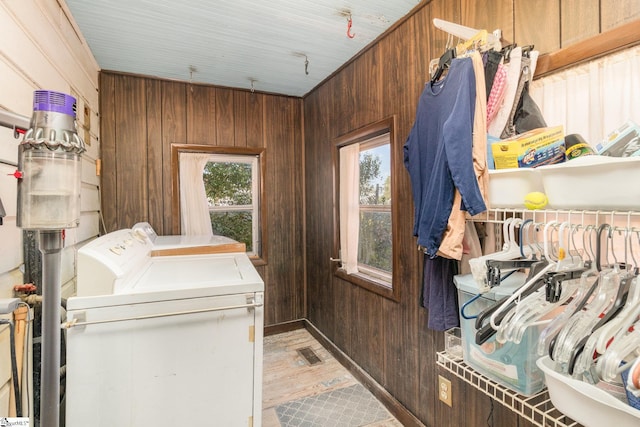 laundry area with washing machine and clothes dryer, laundry area, visible vents, and wooden walls