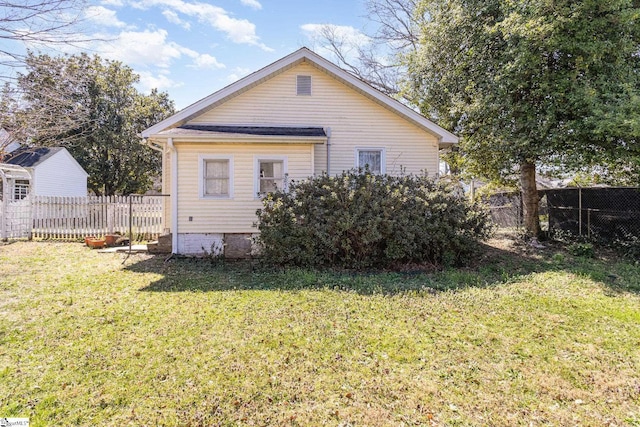 rear view of property with a lawn and fence