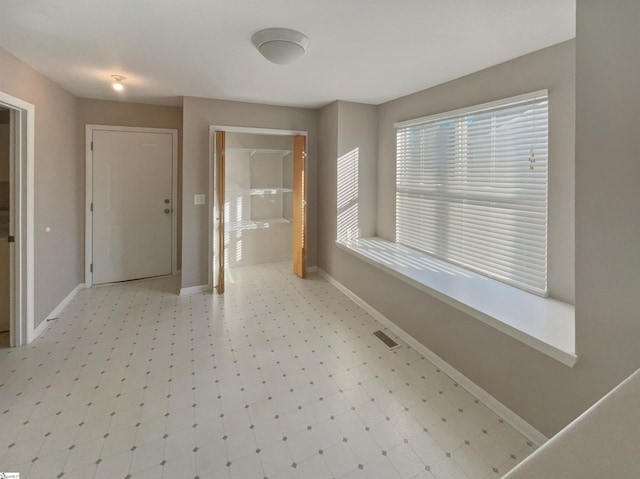 interior space featuring visible vents, baseboards, and light floors