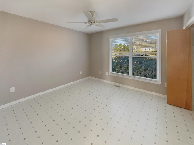 empty room with visible vents, baseboards, and ceiling fan