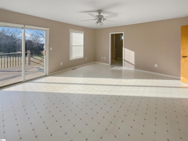 unfurnished room with a ceiling fan and baseboards