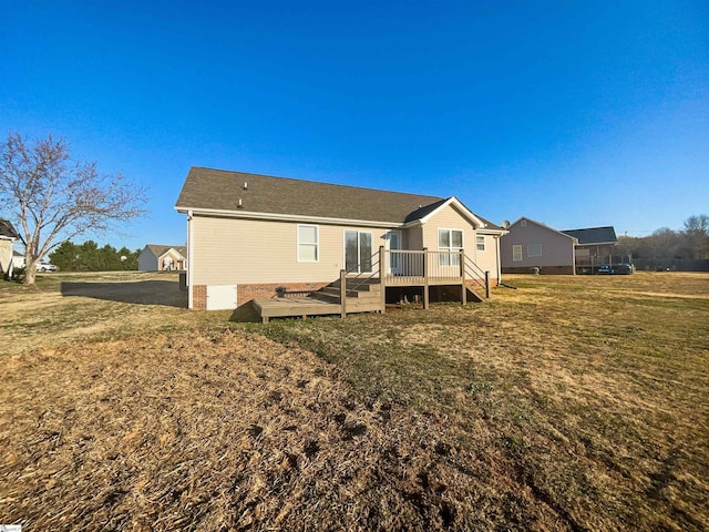 back of property with a wooden deck and a yard