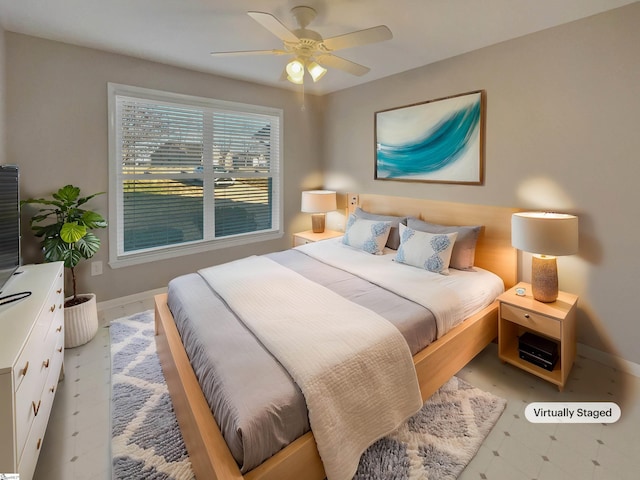 bedroom featuring a ceiling fan, baseboards, and light floors