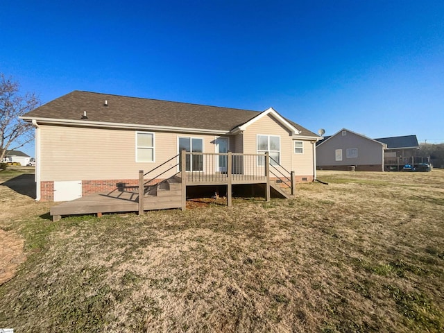 rear view of property featuring crawl space, a yard, roof with shingles, and a wooden deck