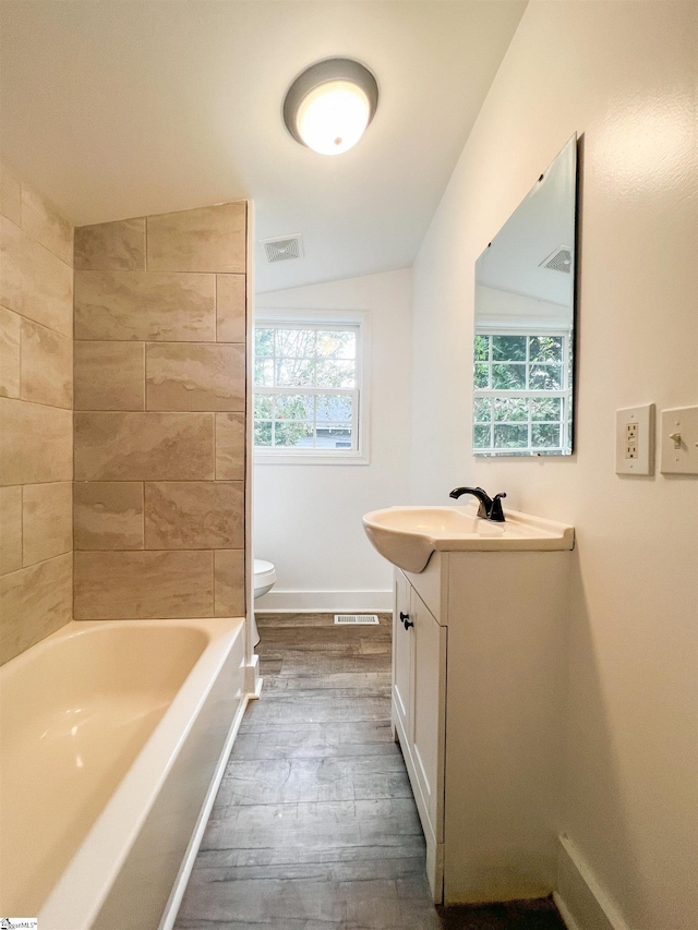 full bath with visible vents, toilet, baseboards, a bathtub, and vanity