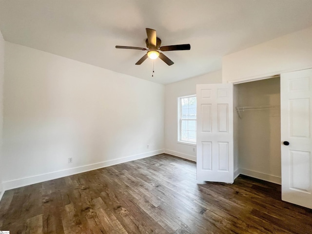 unfurnished bedroom featuring dark wood-style floors, baseboards, a closet, and ceiling fan