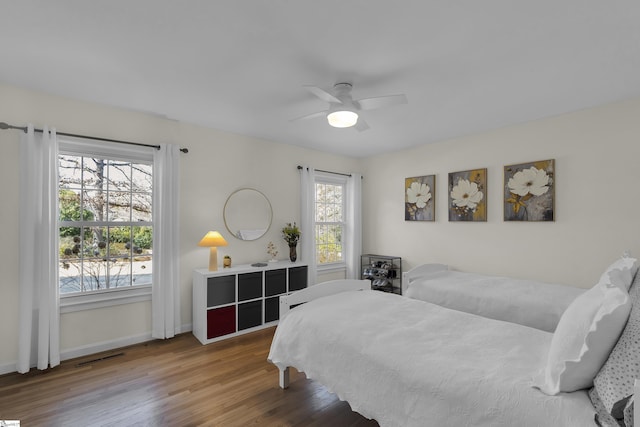 bedroom with a ceiling fan, baseboards, and wood finished floors