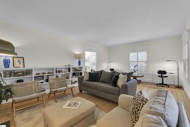 living room featuring wood finished floors, baseboards, and ornamental molding