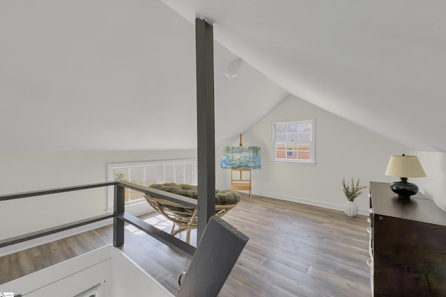 interior space with baseboards, lofted ceiling, and wood finished floors