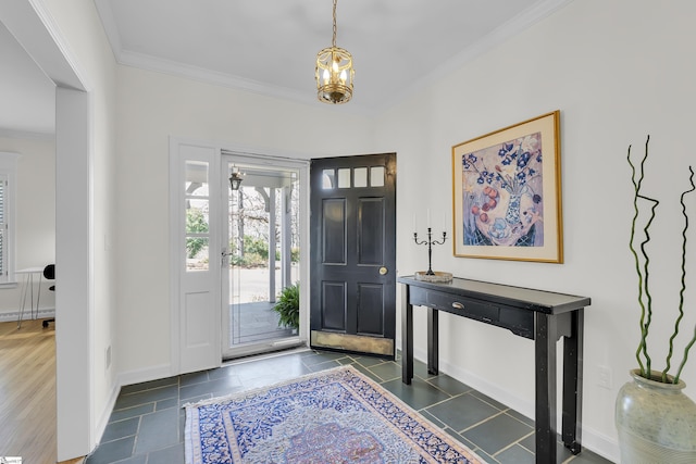 foyer entrance with a notable chandelier, baseboards, and ornamental molding