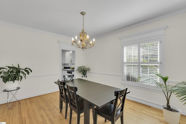 dining space featuring light wood-style flooring, baseboards, a chandelier, and ornamental molding