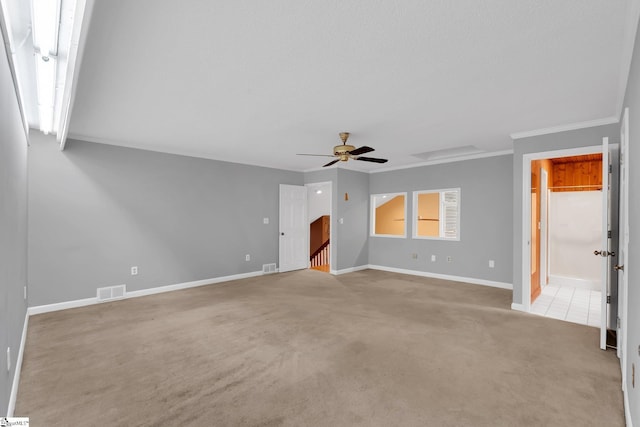 interior space featuring light carpet, visible vents, a ceiling fan, and baseboards