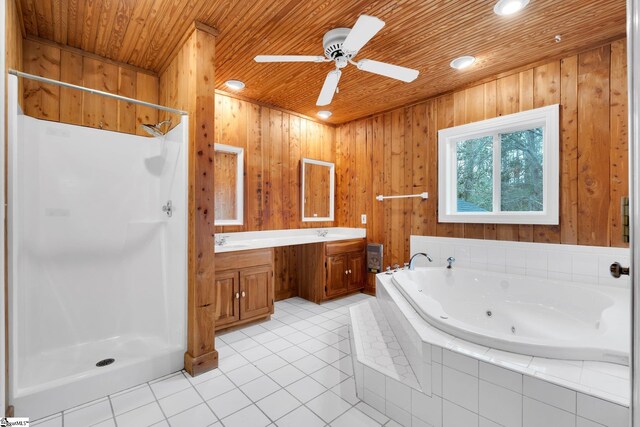 full bathroom with tile patterned floors, a tub with jets, double vanity, and a shower stall