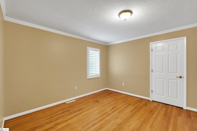 spare room with visible vents, crown molding, baseboards, light wood-style floors, and a textured ceiling