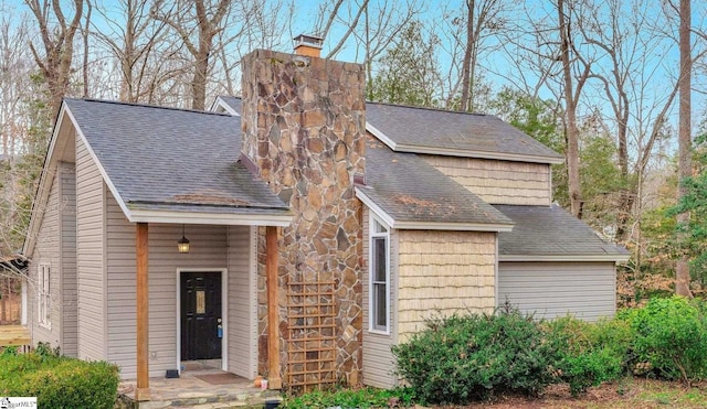 view of front of home featuring roof with shingles and a chimney