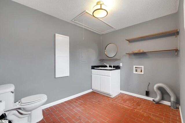 clothes washing area featuring baseboards, attic access, laundry area, brick floor, and a sink