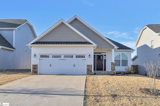 craftsman-style home with metal roof, a garage, stone siding, driveway, and a standing seam roof