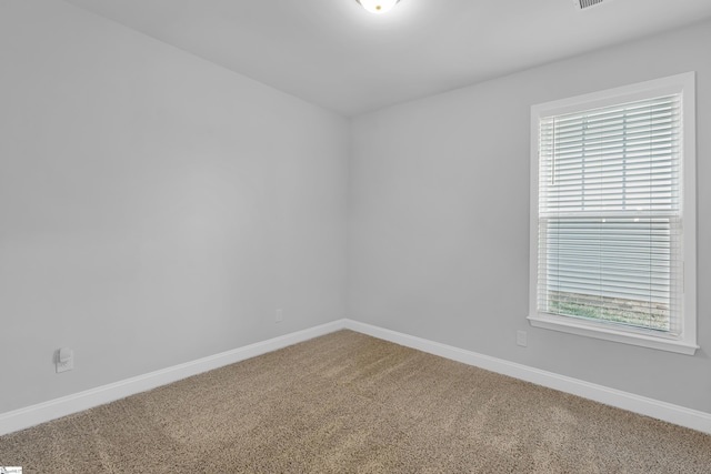 unfurnished room with baseboards and carpet floors