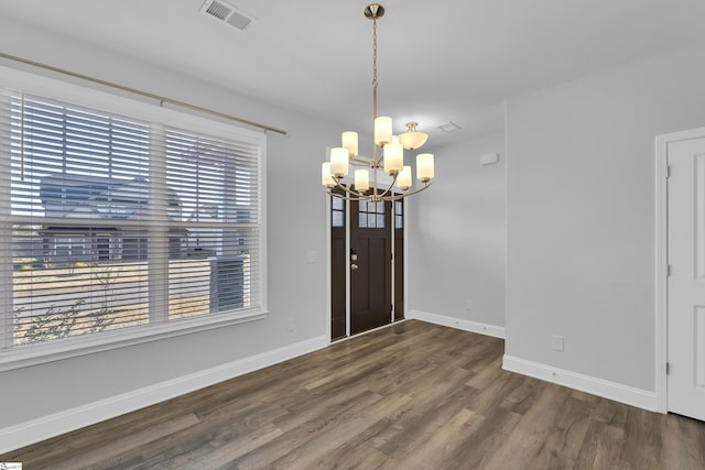 interior space with a chandelier, visible vents, baseboards, and wood finished floors