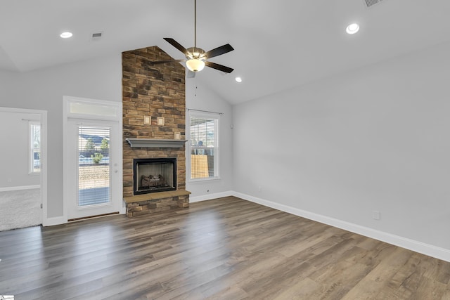 unfurnished living room with high vaulted ceiling, plenty of natural light, dark wood-type flooring, and a fireplace