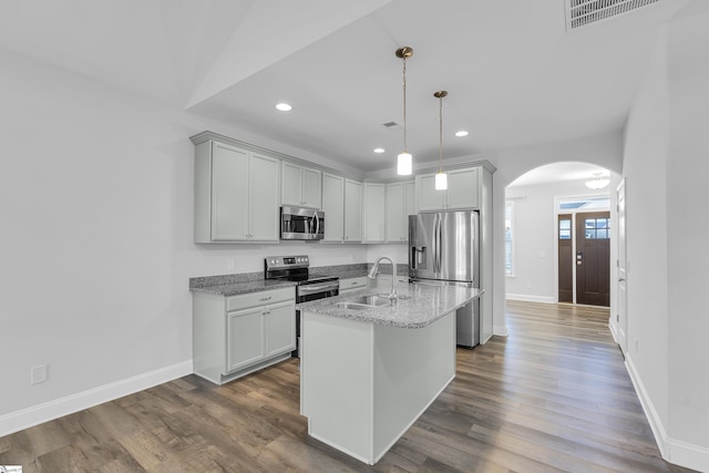 kitchen featuring visible vents, dark wood-style flooring, arched walkways, a sink, and appliances with stainless steel finishes