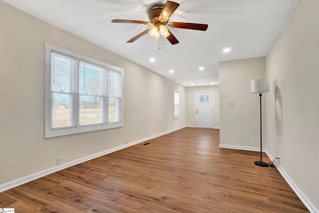 unfurnished room featuring visible vents, a ceiling fan, wood finished floors, recessed lighting, and baseboards