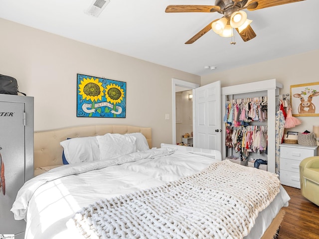 bedroom featuring ceiling fan, visible vents, a closet, and wood finished floors