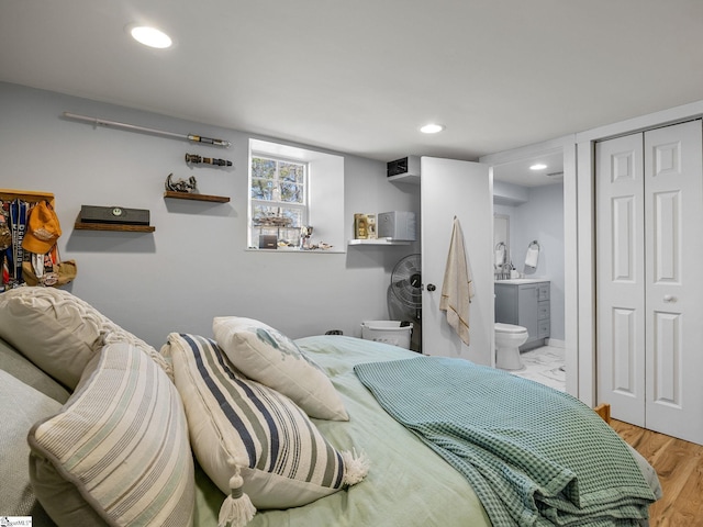 bedroom featuring wood finished floors, recessed lighting, a closet, and connected bathroom