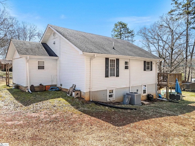 back of property with central AC, roof with shingles, and a wooden deck