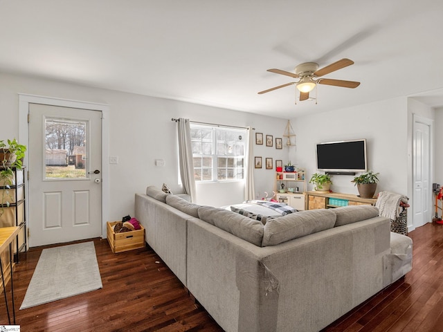 living room with dark wood-type flooring and a ceiling fan