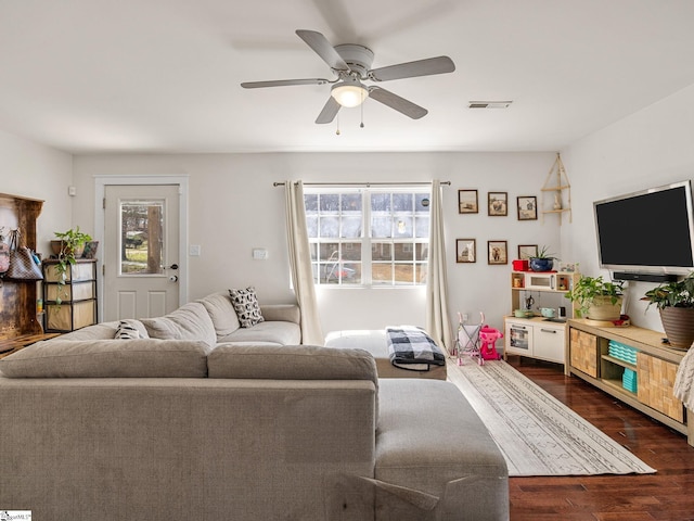 living area with dark wood-type flooring, a ceiling fan, and visible vents