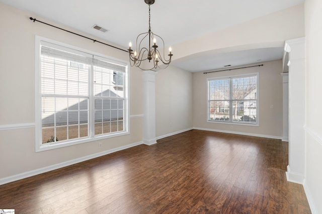 spare room featuring dark wood finished floors, visible vents, baseboards, and an inviting chandelier