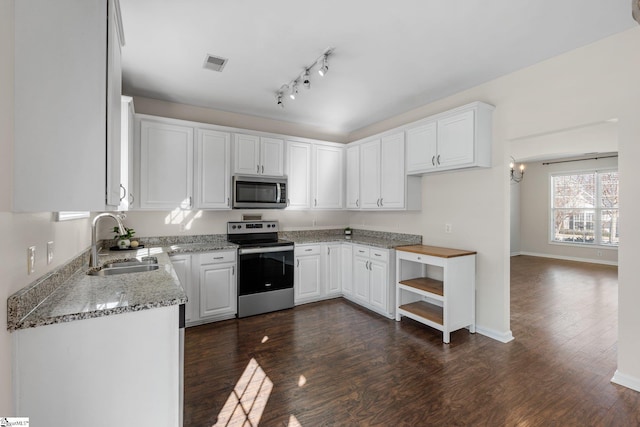 kitchen with visible vents, a sink, stainless steel appliances, dark wood-type flooring, and white cabinetry