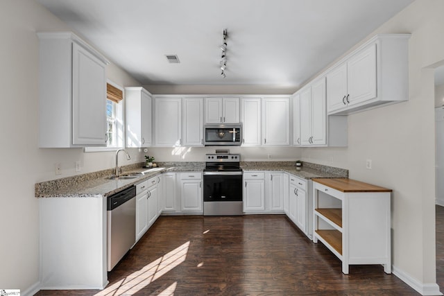 kitchen featuring white cabinets, visible vents, appliances with stainless steel finishes, and a sink