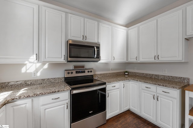 kitchen featuring light stone countertops, white cabinetry, stainless steel appliances, and dark wood-style flooring