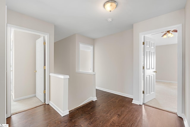 empty room with baseboards and dark wood-style flooring