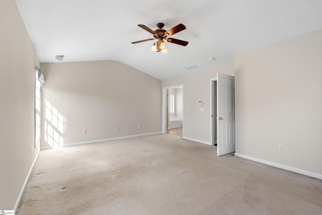 empty room with a wealth of natural light, baseboards, light carpet, and lofted ceiling