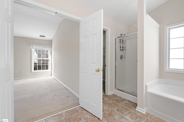 bathroom featuring a shower stall, a healthy amount of sunlight, and visible vents