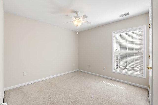 empty room featuring carpet flooring, baseboards, visible vents, and ceiling fan